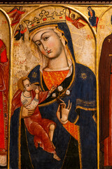 Obraz premium Iconic medieval painting portraiting Virgin Mary making a symbolic gesture with her hand while holding Jesus as a boy