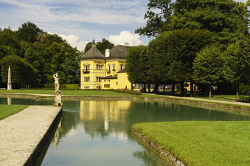 Salzburg, Austria - August 18, 2012: Summer view of pond and trail with trees on the garden of luxury house
