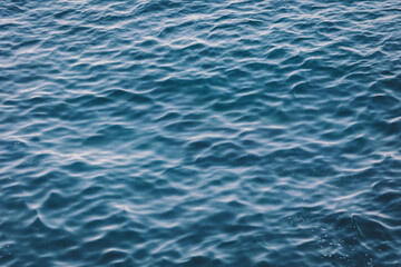 An abstract background of seawater flow under light exposure. A picture of the sea with calm waves. 