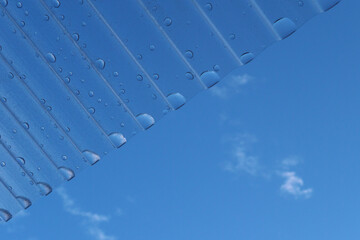 トタン屋根・水滴・青空・雲