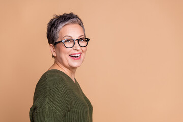 Side profile photo of good mood woman with short hair dressed sweater in glasses toothy smiling isolated on beige color background