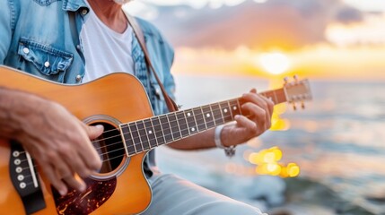 Obraz premium A man is playing an acoustic guitar by the ocean at sunset, creating a peaceful and relaxing atmosphere with the sun setting behind the ocean horizon, casting a golden glow.