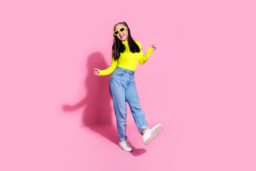 Full size photo of good mood girl with dyed hair dressed yellow shirt jeans in sunglass dancing at party isolated on pink color background