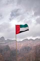 flag waving in the wind in UAE mountains