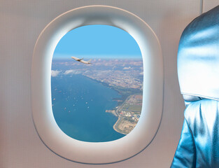 Naklejka premium Airplane taking off from Changi Airport - Passenger airplane is flying over amazing sea as seen through window of an aircraft - Commercial Tankers and container ships wait in the Straits of Singapore