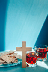 Biblical communion with wine and bread on blue background, religion vertical card with christian tradition and symbols