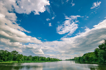 A beautiful blue sky with clouds and a river in the background