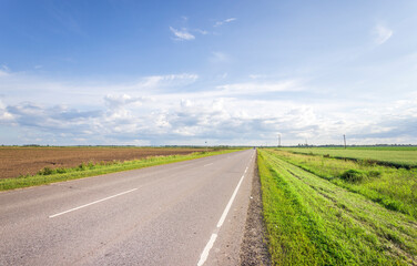 A road with a grassy median and a clear blue sky