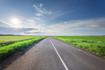 A long, empty road with a clear blue sky above