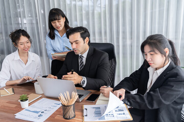 Diverse group of business analyst team analyzing financial data report paper on office table. Chart and graph dashboard by business intelligence analysis for strategic marketing planning Meticulous