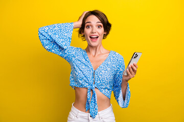 Photo of excited shiny lady dressed flower print top online shopping modern gadget isolated yellow color background