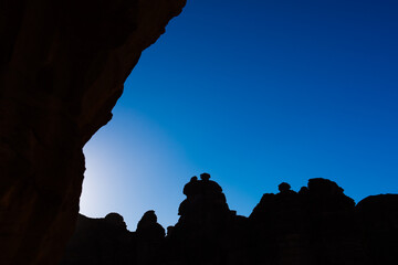 The silhouette of huge rugged rocks against the sun in Al Ula Saudi Arabia