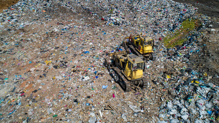 Aerial view of two bulldozers working in a large landfill