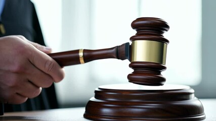 The judge holds a gavel in his hand and hits a wooden stand in the courtroom.
Concept: legal content, law and legal proceedings.