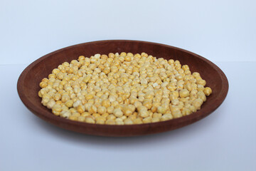 Chickpeas in wooden plate, isolated on white background