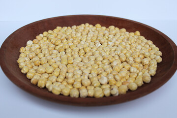Chickpeas in wooden plate, isolated on white background