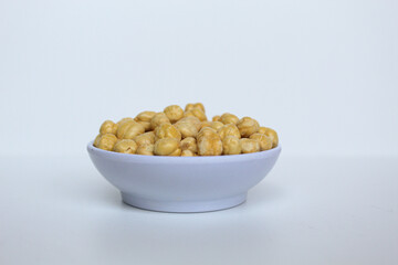 Chickpeas in small white bowl, isolated on white background