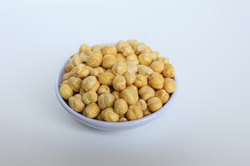 Chickpeas in small white bowl, isolated on white background