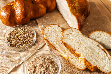 Pigtail bread and sliced bread on canvas cloth with ingredients in petri bowls