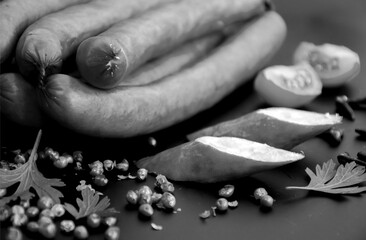 Tasty sausages and vegetables isolated over solid background. Black and white grayscale photo background