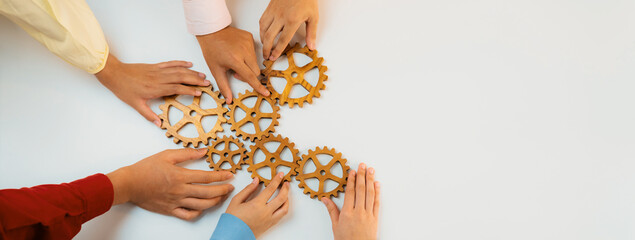 Obraz premium Startup company employee joining cogwheel gear together symbolize function productive system and synergy teamwork with young people start company with creative and collaboration. Panorama Synergic