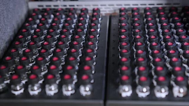 HPLC glass vials with black caps in the auto sampler are waiting for injection. 