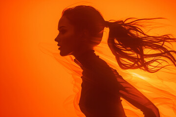 athletic female in vibrant motion, silhouetted against an orange background, showcasing the power and grace of fitness, ideal for promoting a unique and creative approach to exercise routines