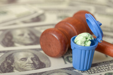The sight of a judge's gavel with money and a trash bin, accompanied by a fine, symbolizes the...