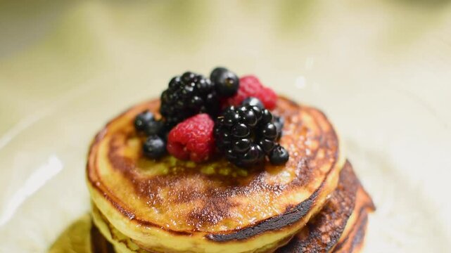 Toma superior de una pila de panqueques con miel y frutos rojos 