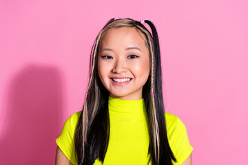 Photo of optimistic adorable chinese girl with dyed hairstyle dressed yellow t-shirt toothy smiling isolated on pink color background