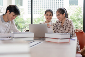 Group of Happy Students Studying Together with Laptops and Books in a Bright Modern Classroom