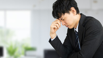 考えごとをする男性ビジネスマン