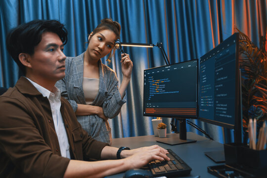 IT developers discussing with point to intelligent website development coder system running data online two screens information technology at neon light room at modern office. Infobahn.