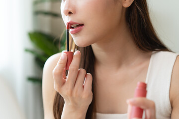 Skin care, beauty cosmetics concept, pretty asian young woman, girl make up face by applying red...
