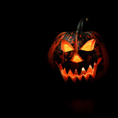 Halloween pumpkin with scary face on black background.