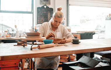 Woman, clay and pottery tool in studio for ceramics, shape and craft into pattern with detail....