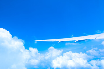 飛行機の窓から見た青空と飛行機の翼