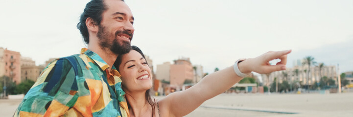Newlyweds hug and talk while standing on the coast, panorama