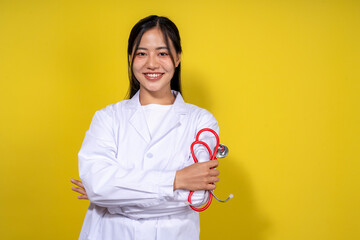 A woman in a white lab coat is holding a stethoscope