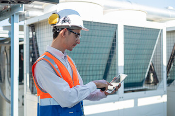 Engineer under checking the industry chilled water fan coil unit air conditioner is water cooling tower air chiller HVAC system of large industrial building to control air system