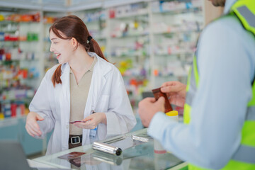 A pharmacist prepares medicine on the counter of a pharmacy. At the back there is a shelf that stores drug samples and chemical products.