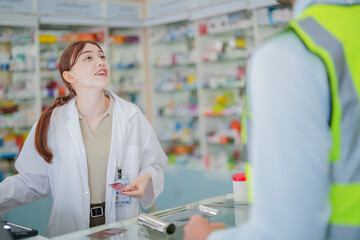 A pharmacist prepares medicine on the counter of a pharmacy. At the back there is a shelf that stores drug samples and chemical products.