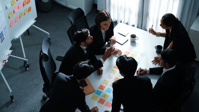Top view of smart executive manager discuss and choose marketing idea from sticky notes. Group of business team talking and brainstorming strategy while making decision and choose plan. Directorate.