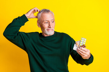 Photo portrait of handsome retired man look confused pills wear trendy green outfit isolated on...