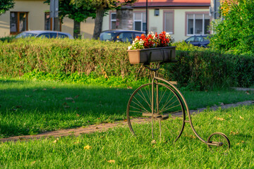 Interesting decoration with flowers on a green lawn in the city. bicycle decoration © Adam