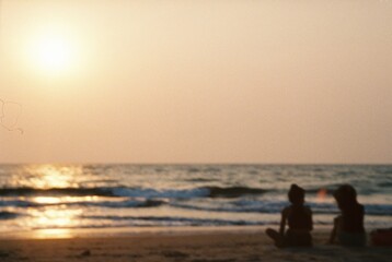 people walking on the beach at sunset