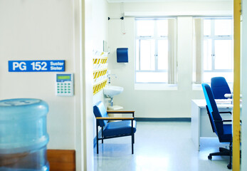Hospital, consultation room and interior of doctor office for medical insurance, help or treatment. Chairs, desk and doorway of empty space in clinic for healthcare, checkup service or diagnosis.