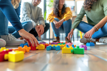 Adults sitting on a wooden floor assembling colorful plastic building blocks in a casual setting. Team-building exercises, creativity stimulation, collaborative projects, stress-relief activities.