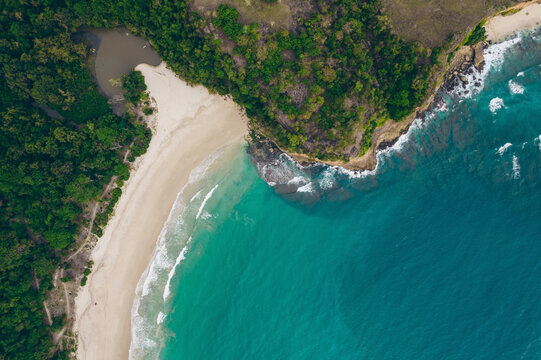 Coastline of Bukit Merese viewed from directly above with white sand beach and trees on Lombok, Indonesia; Lombok, West Nusa Tenggara, Indonesia