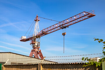 A large crane on the property of a heavy industry company.